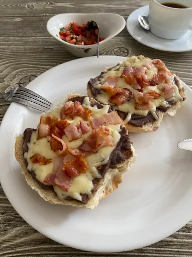 Molletes con frijol, queso fundido y tocino con pico de gallo